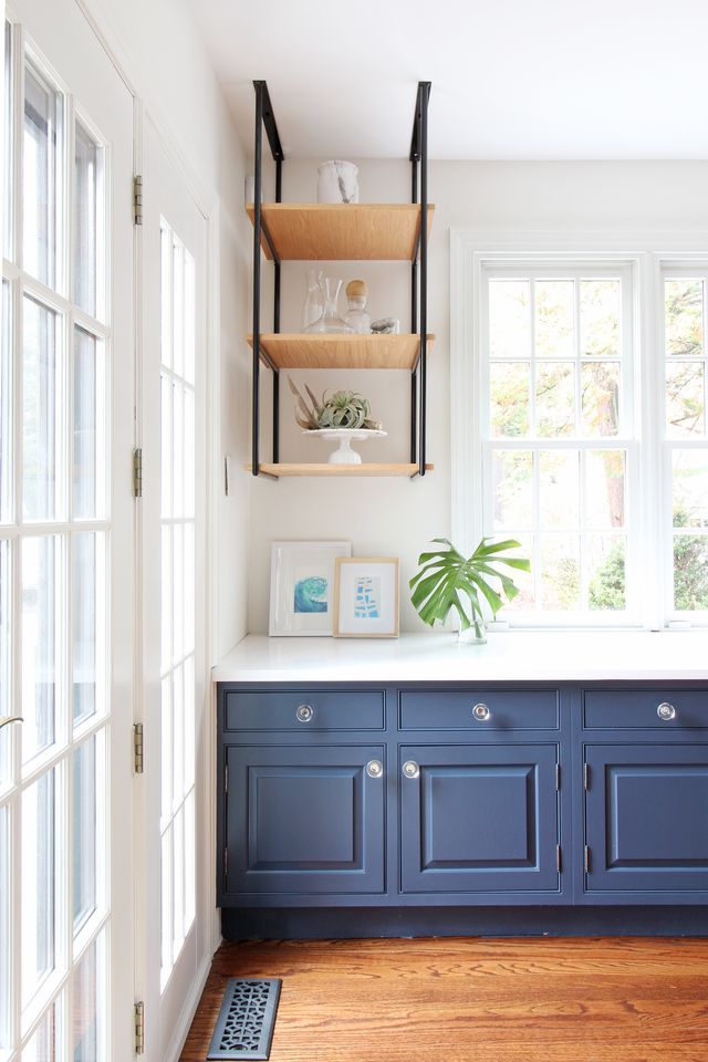 a room with blue cabinets and a shelf with pictures on it