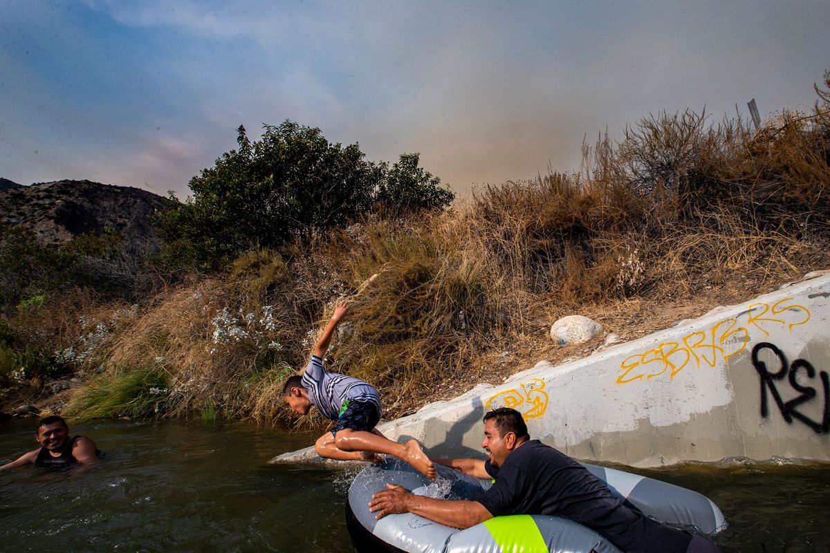 Tijdens de recente hittegolf in Californi ravotten Eddie Lopez en zijn zoon Eddie Jr in de buurt van een afwatering langs de rivier San Gabriel