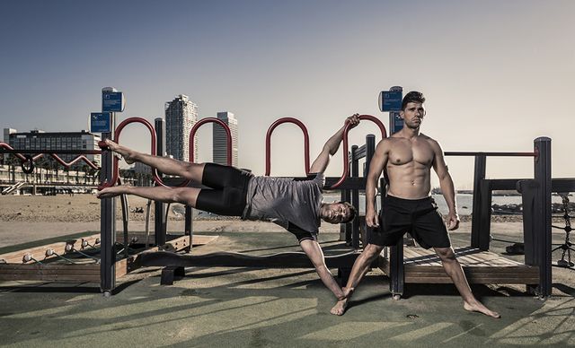 two men practicing calisthenics in urban work out park in barcelona spain