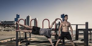 two men practicing calisthenics in urban work out park in barcelona spain