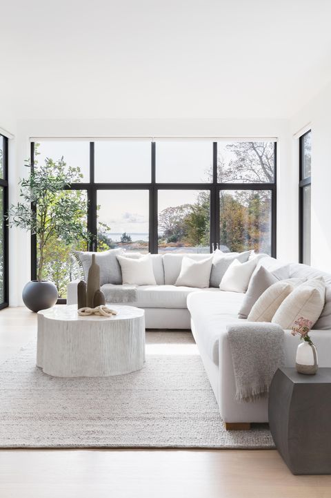 grey couch, wood coffee table, grey rug, grey throw, glass doors