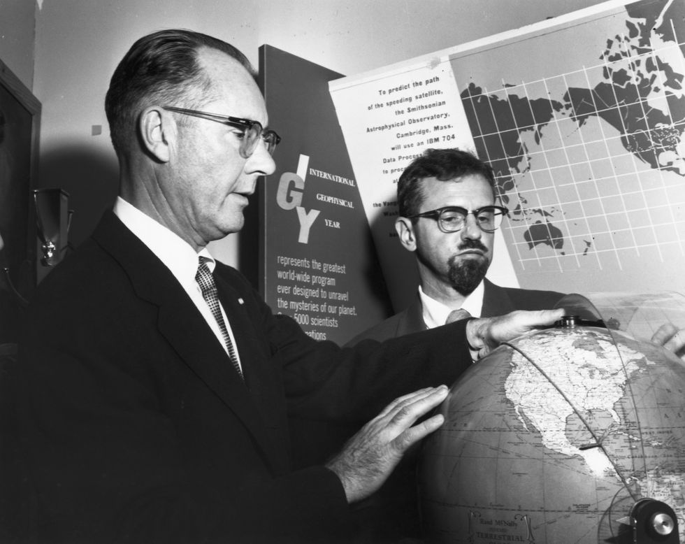 two men looking at globe