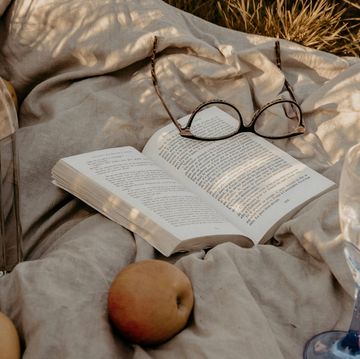a book and glasses on a blanket