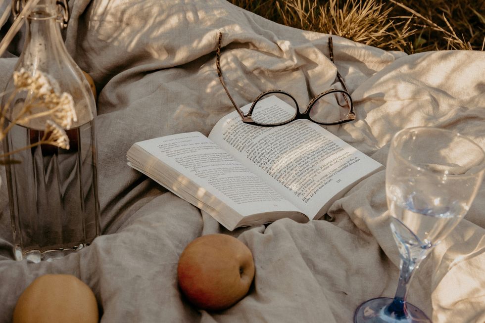 a book and glasses on a blanket