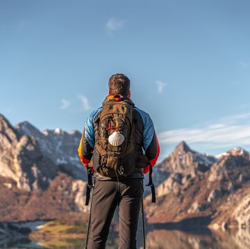 camino de santiago hiker with backpack and shell looking at the landscape