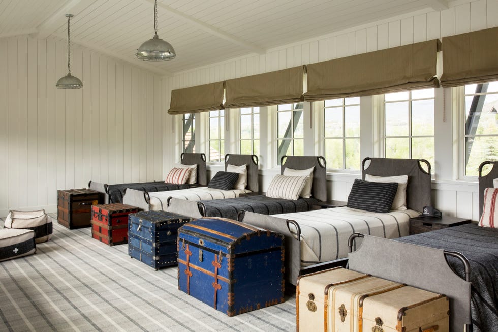 guest bedroom with barrack style or summer camp inspired row of metal beds