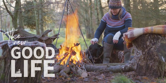 a person sitting on a log next to a campfire