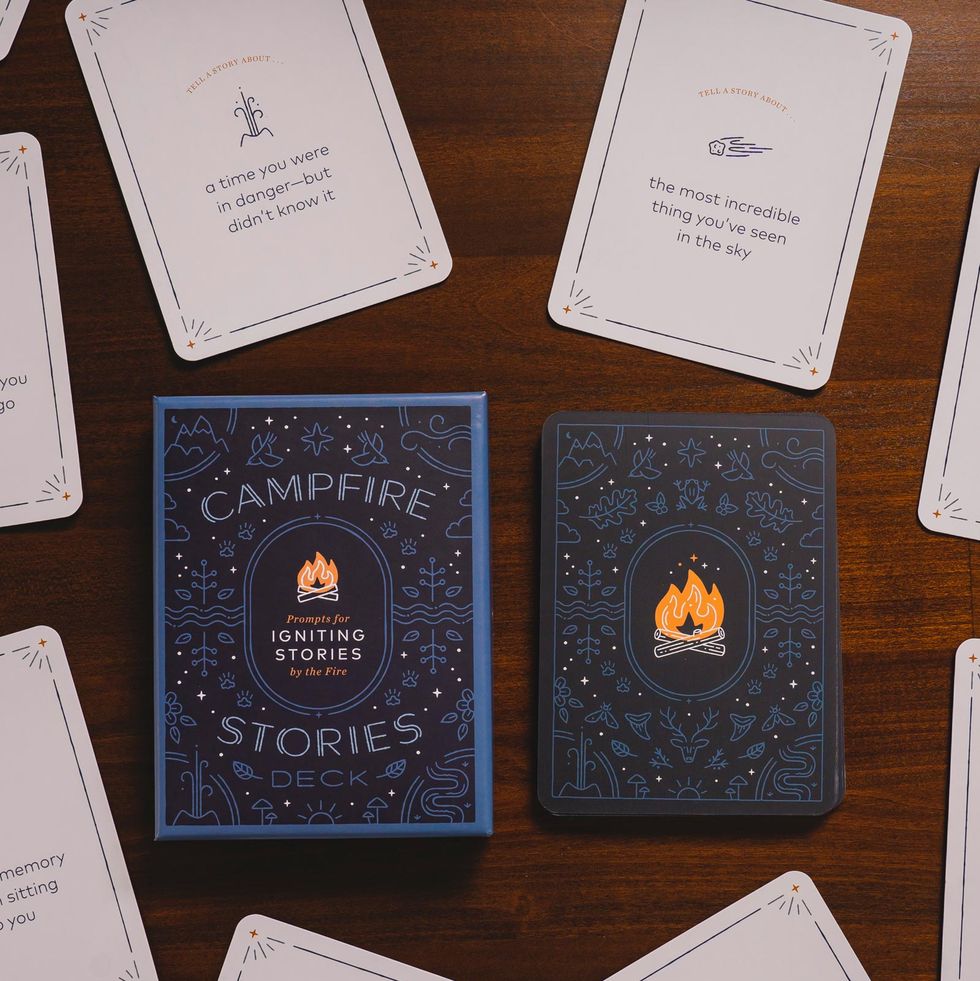 a deck of campfire stories with assorted prompt cards on a wooden table campfire stories is a good housekeeping pick for best camping activity