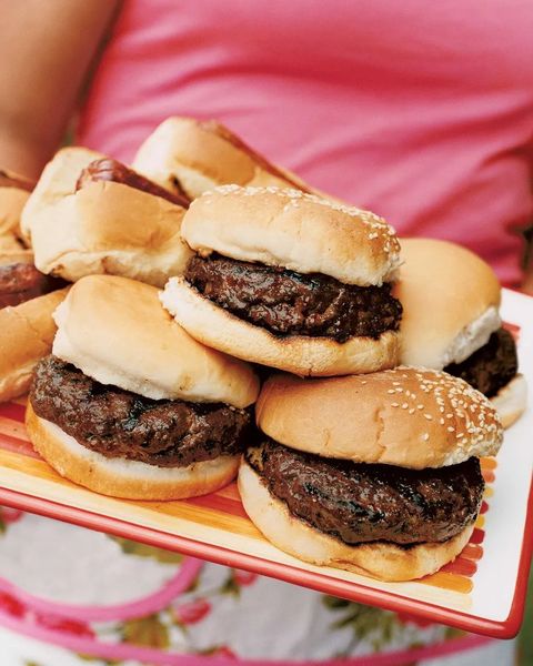 grilled burgers stacked and arranged on a red and orange serving tray
