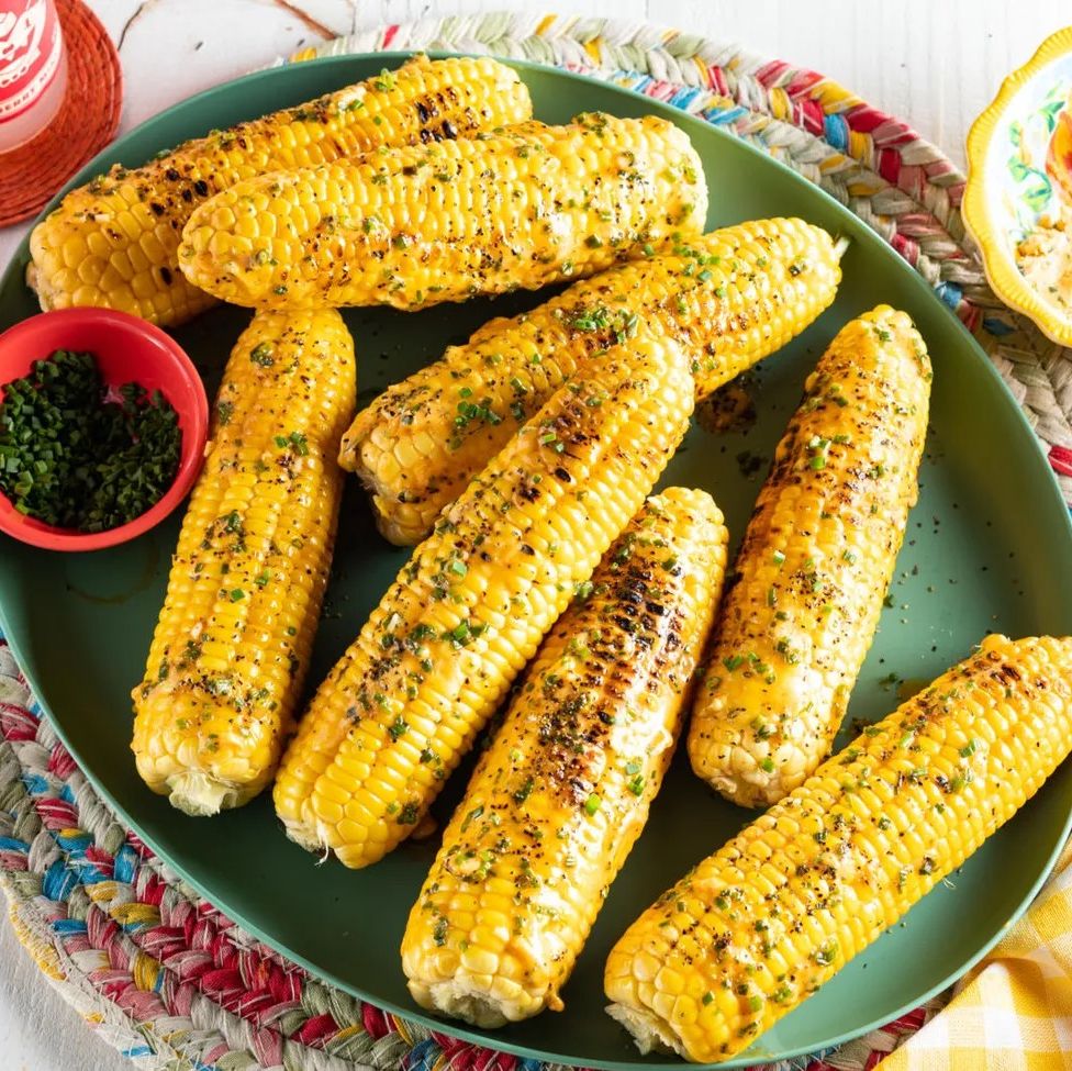 corn on the cob with herbs on green platter