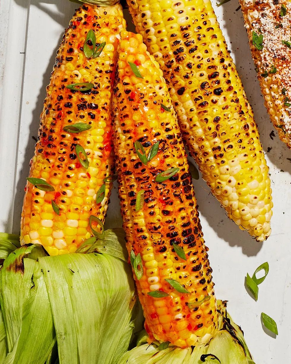 grilled pepper jelly corn arranged on a white wooden tray