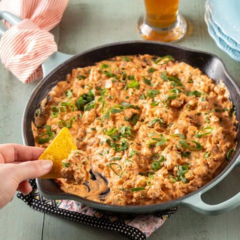 sausage dip in skillet with chip