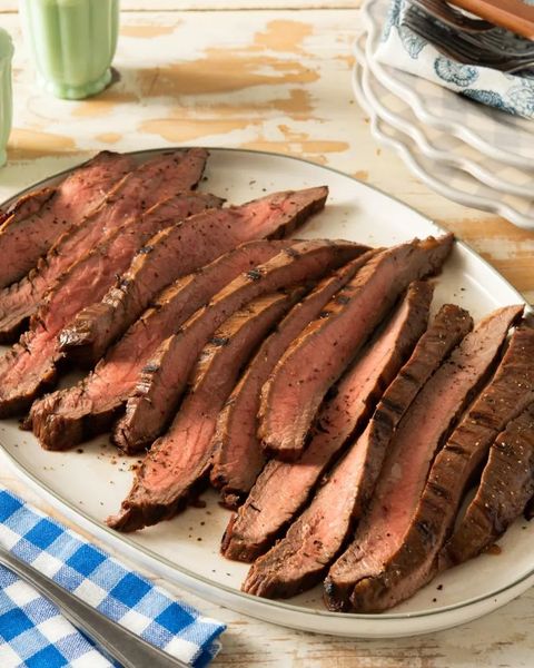 simple grilled flank steak on platter with blue checkered napkin