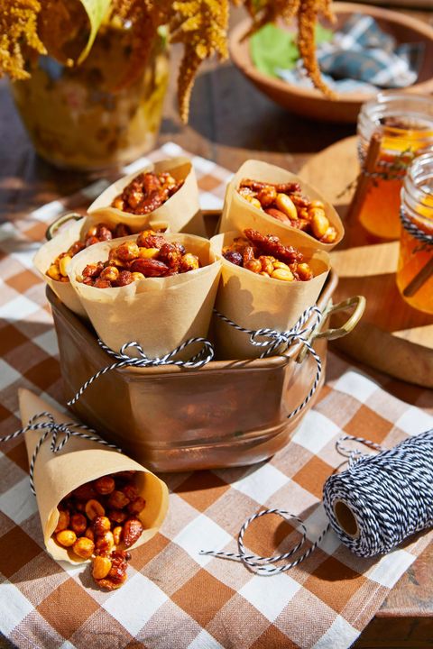 spicy and sweet snack mix in paper cones arranges in a copper serving dish on a picnic table