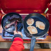 cooking bacon and pancakes on red camping stove