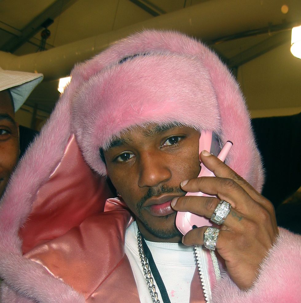 a famous photo of the rapper cam'ron wearing a pink fur coat and holding on a pink mobile phone up to his ear