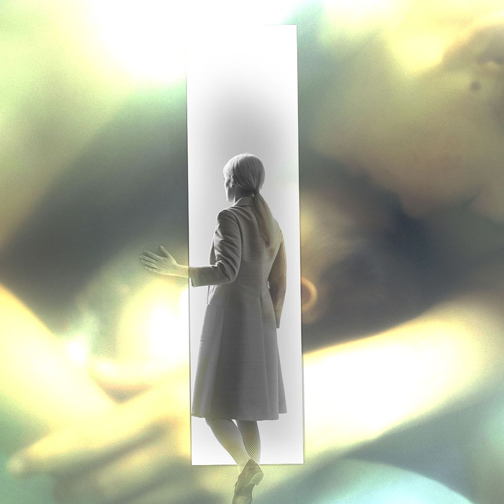 an ethereal image of a woman walking out of a door