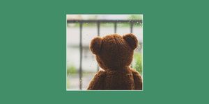 teddy bear sitting next to a rainy window