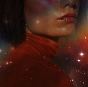 the bottom half of a woman's face and her shoulders are seen, overlaid with a dark, rainbow sky