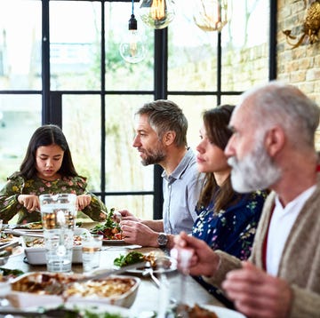 candid portrait of three generation family enjoying dinner together