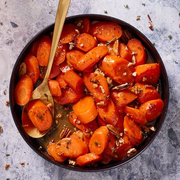 candied carrots with thyme and pecans in a black bowl