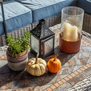 candle lantern and pumpkins on outdoor table
