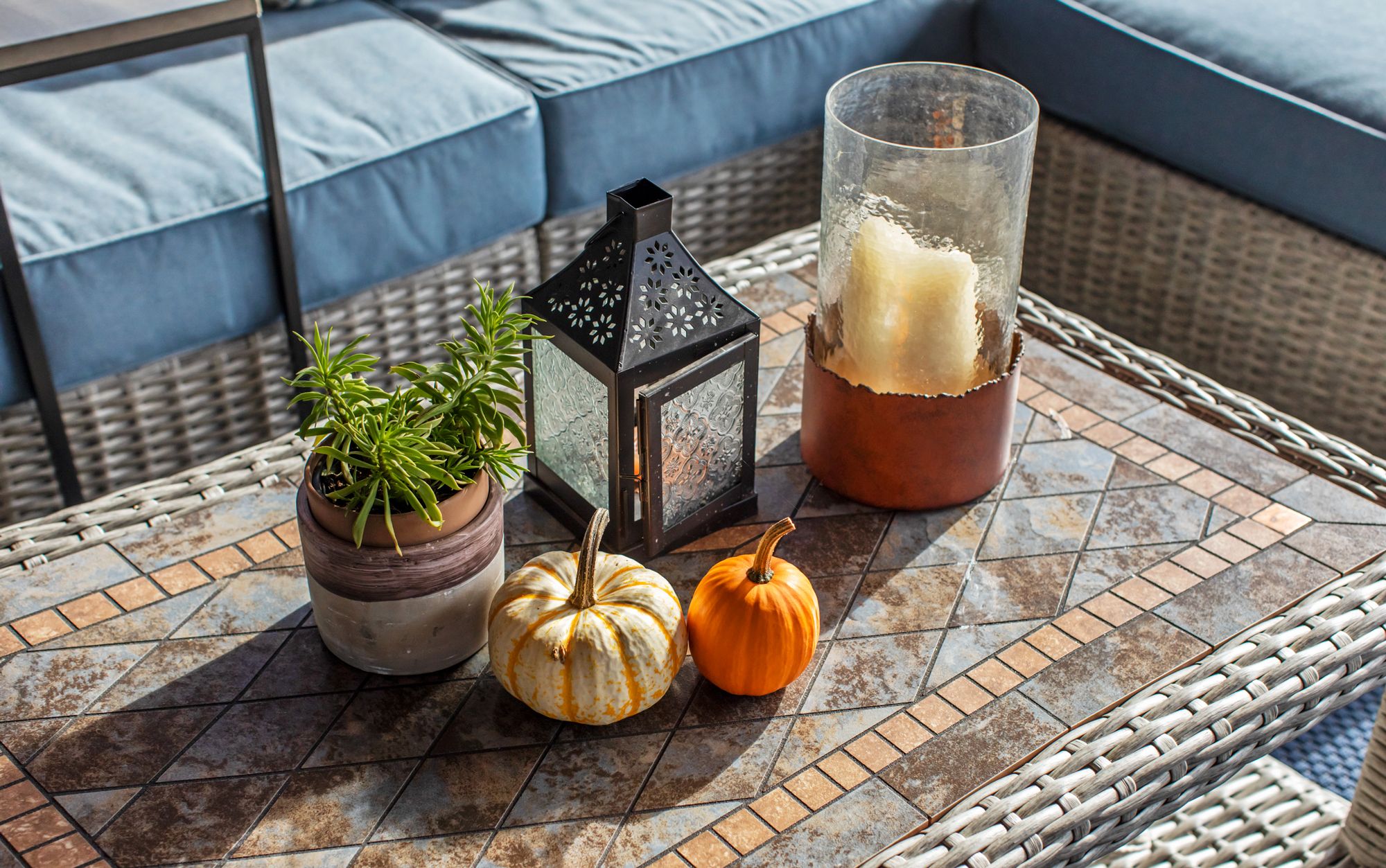 candle lantern and pumpkins on outdoor table