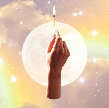 a hand holds up a lit match over a background of a full moon and a cloudy rainbow sky
