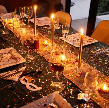 candlelit dining table covered in sparkling confetti during a new year's eve party
