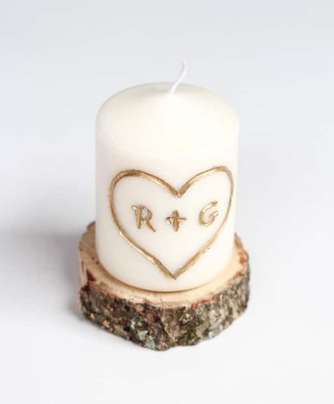 white candle with an engraving that says r  g in gold