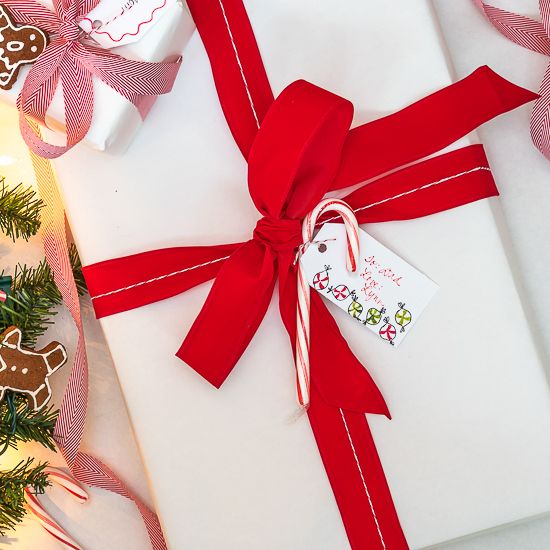 Accessories for packaging Christmas gift ,fir tree branch with red, wrapping  paper, roll of Red and white thread , christmas candy and different wrap  presents. Stock Photo