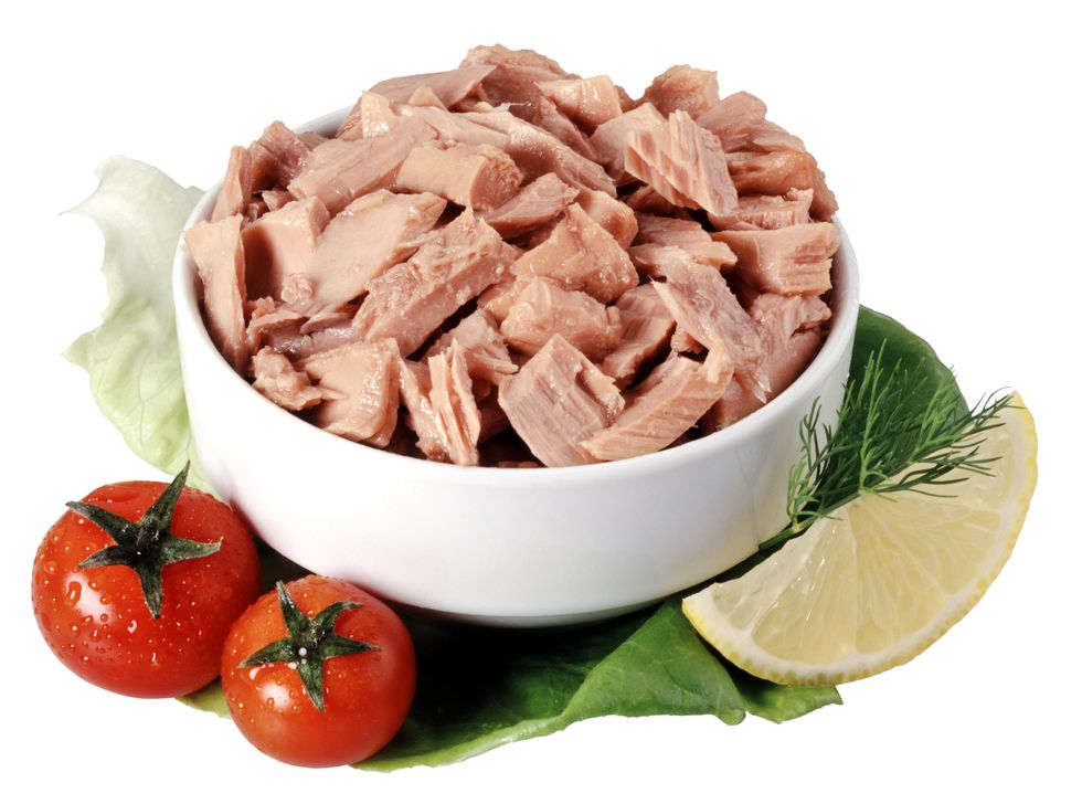 Canned tuna chunks in a bowl garnished with tomatoes