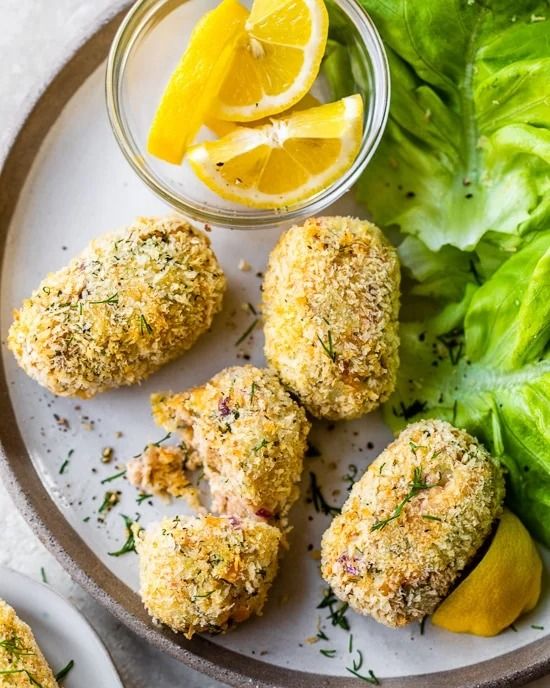 tuna croquettes arranged on a plate with lettuce and lemon slices