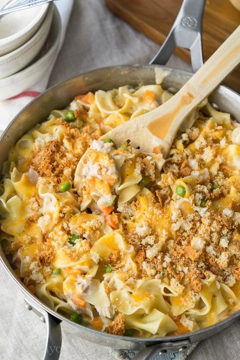 tuna noodle casserole in a metal skillet with a wooden spoon