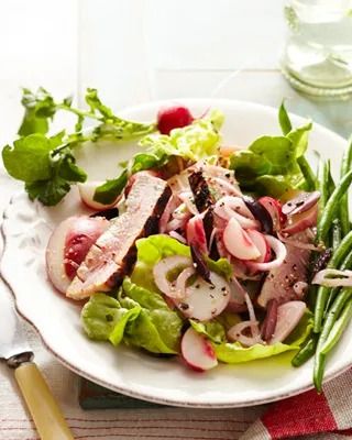 salade provençale with tuna and radishes on a white plate