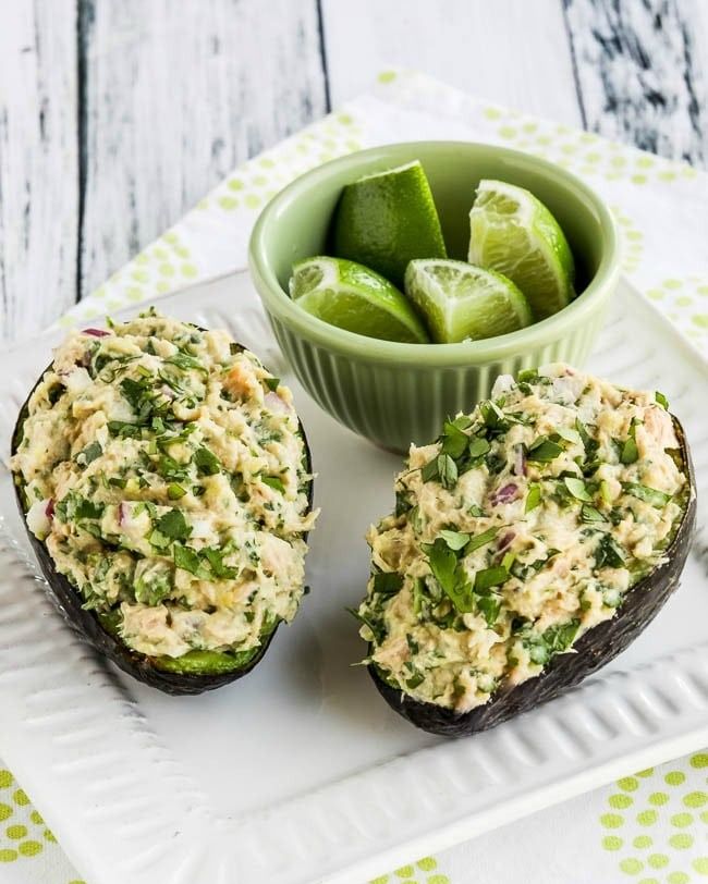 two avocado halves stuffed with cilantro lime tuna salad
