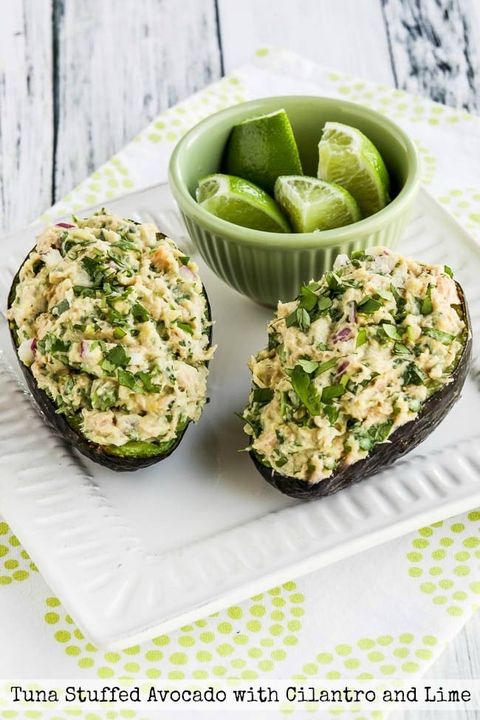 two avocado halves stuffed with cilantro lime tuna salad