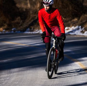 a man riding a bicycle on a road in winter