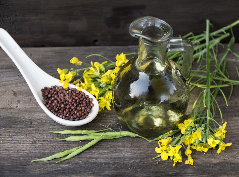canola oil,flowers and seeds on rustic wood