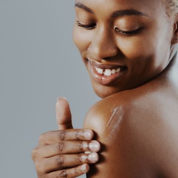 woman applying moisturizer on shoulder