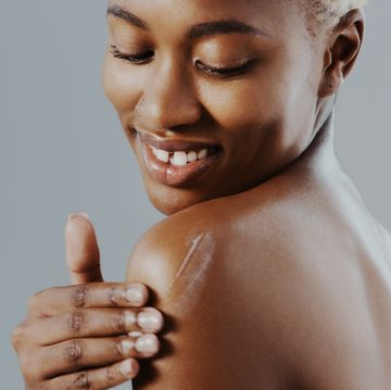 woman applying moisturizer on shoulder