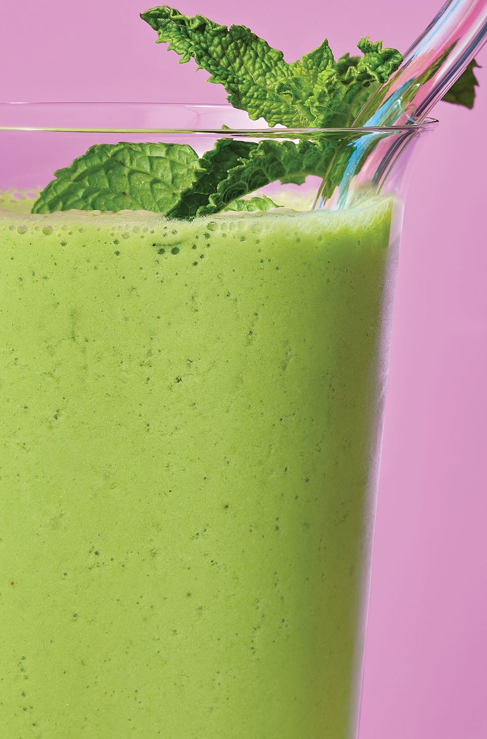 green smoothie in front of purple pink background