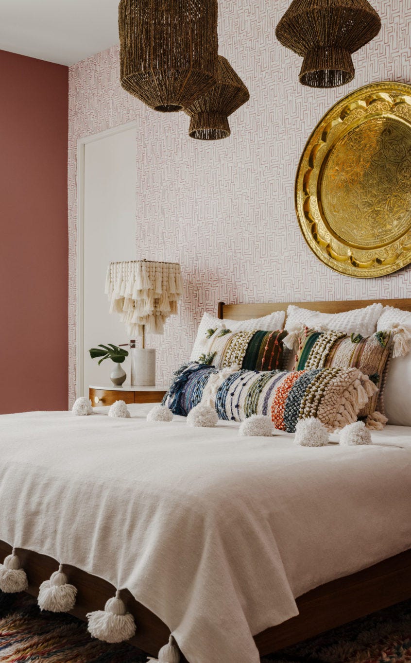 boho bedroom with pink walls and abstract print wallpaper