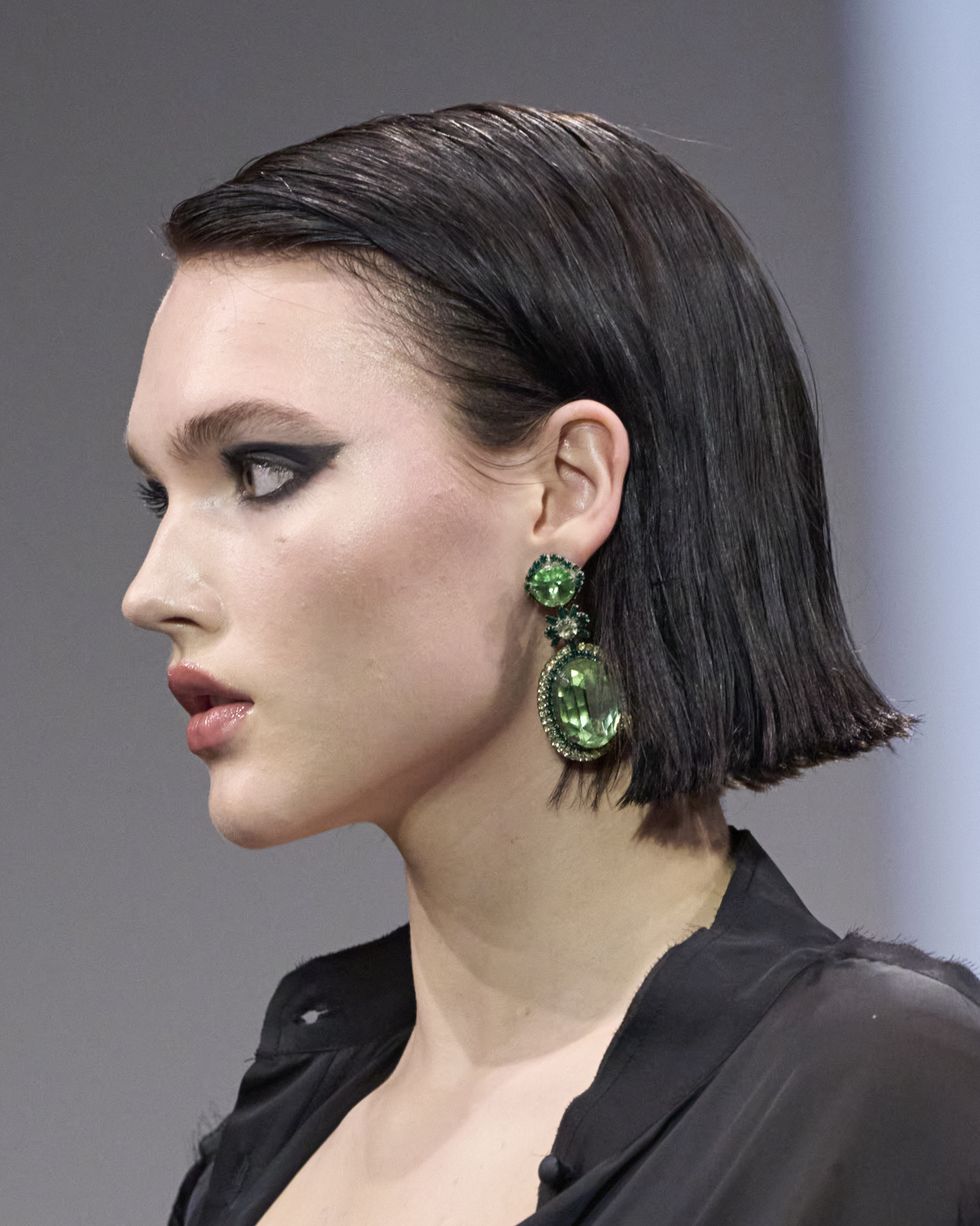 a woman with a green earring
