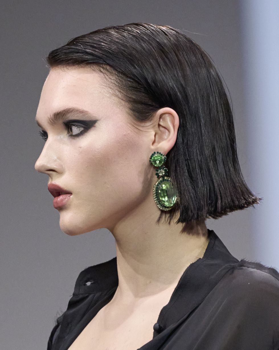 a woman with a green earring