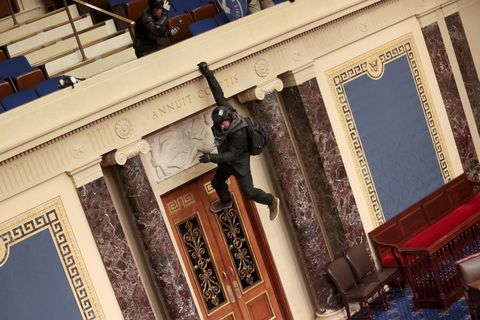 Een Trumpaanhanger hangt aan het balkon van de Senaatskamer