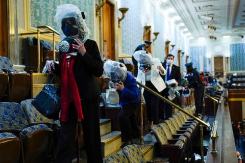 Terwijl aanhangers van president Trump met geweld het Capitool binnendringen zoeken Congresleden en medewerkers op de galerij van het Huis van Afgevaardigden dekking op de vloer in de afgesloten ruimte en zetten gasmaskers op Uiteindelijk werden ze gevacueerd naar een geheime veilige locatie