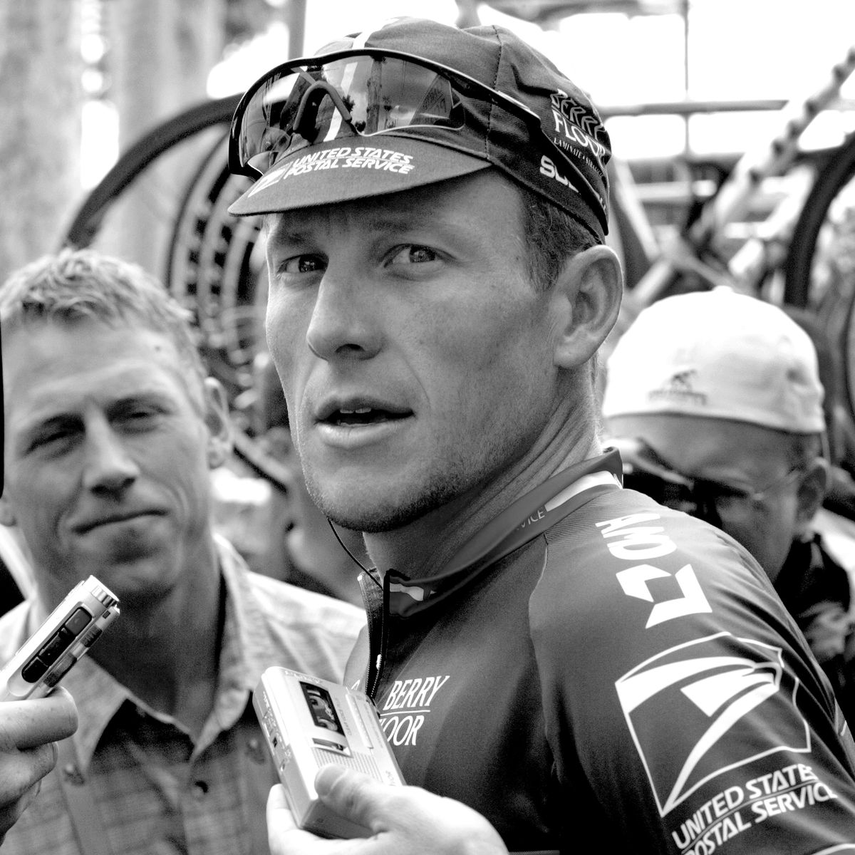 lance armstrong being interviewed by reporters on race day during his time with the us postal service team