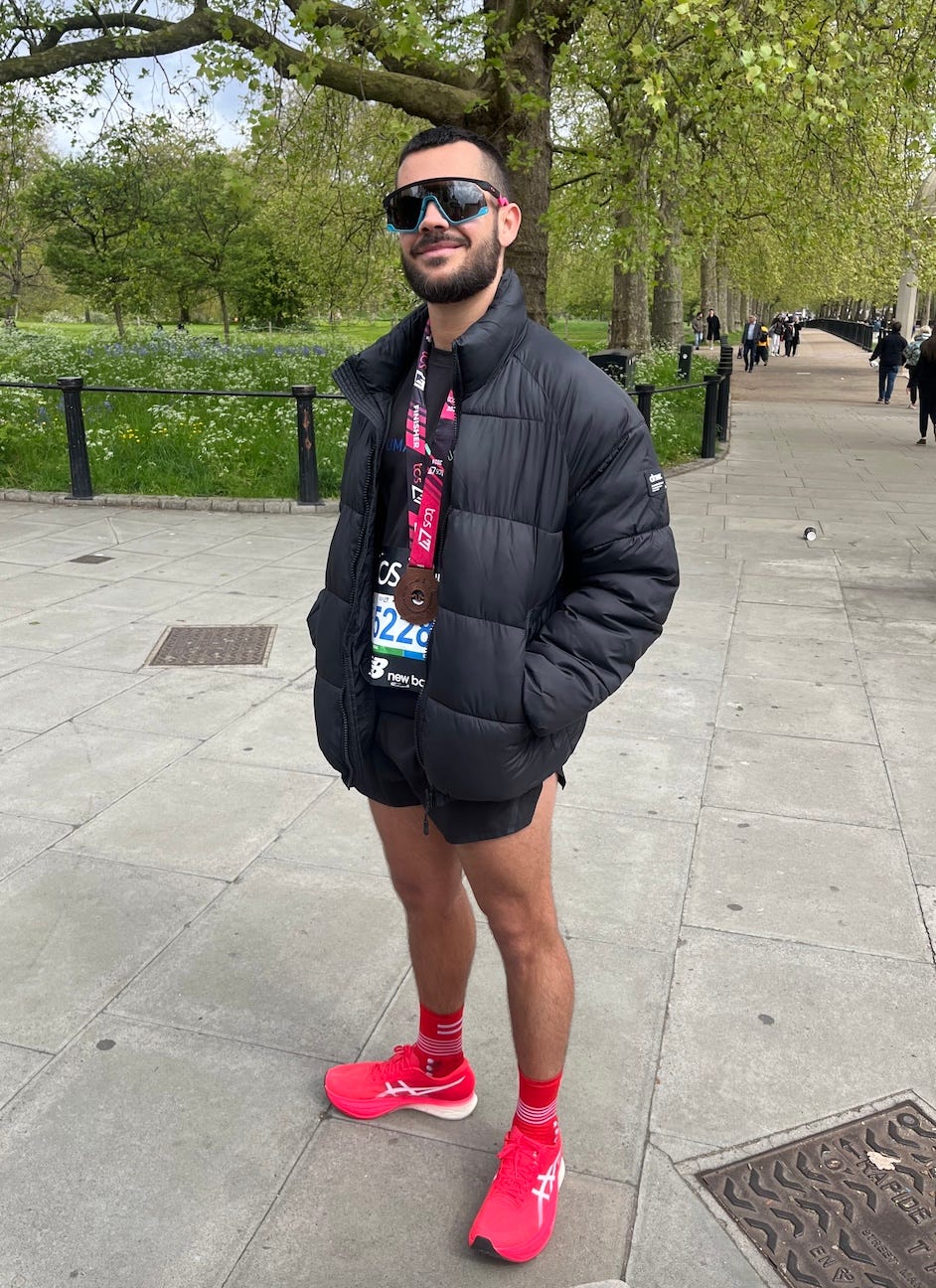 a person wearing sunglasses and a black jacket and red shoes