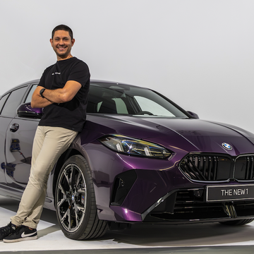 a man leaning against a purple car